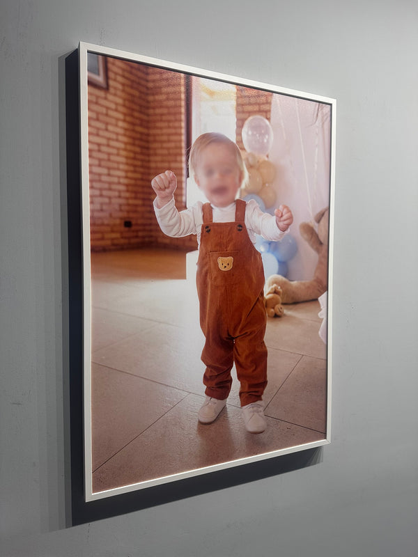 Framed photograph of a child in brown overalls standing indoors.