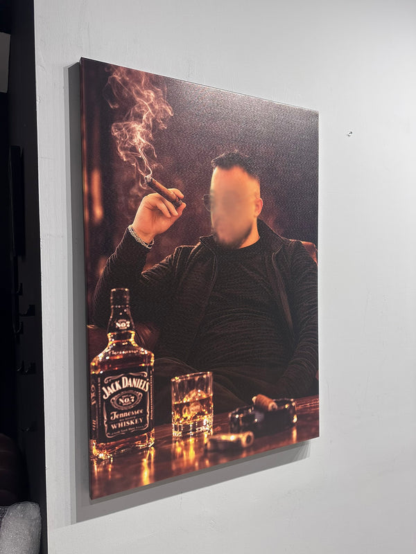 Man smoking a cigar with a Jack Daniel's whiskey bottle and glass on a table, displayed on a wall.