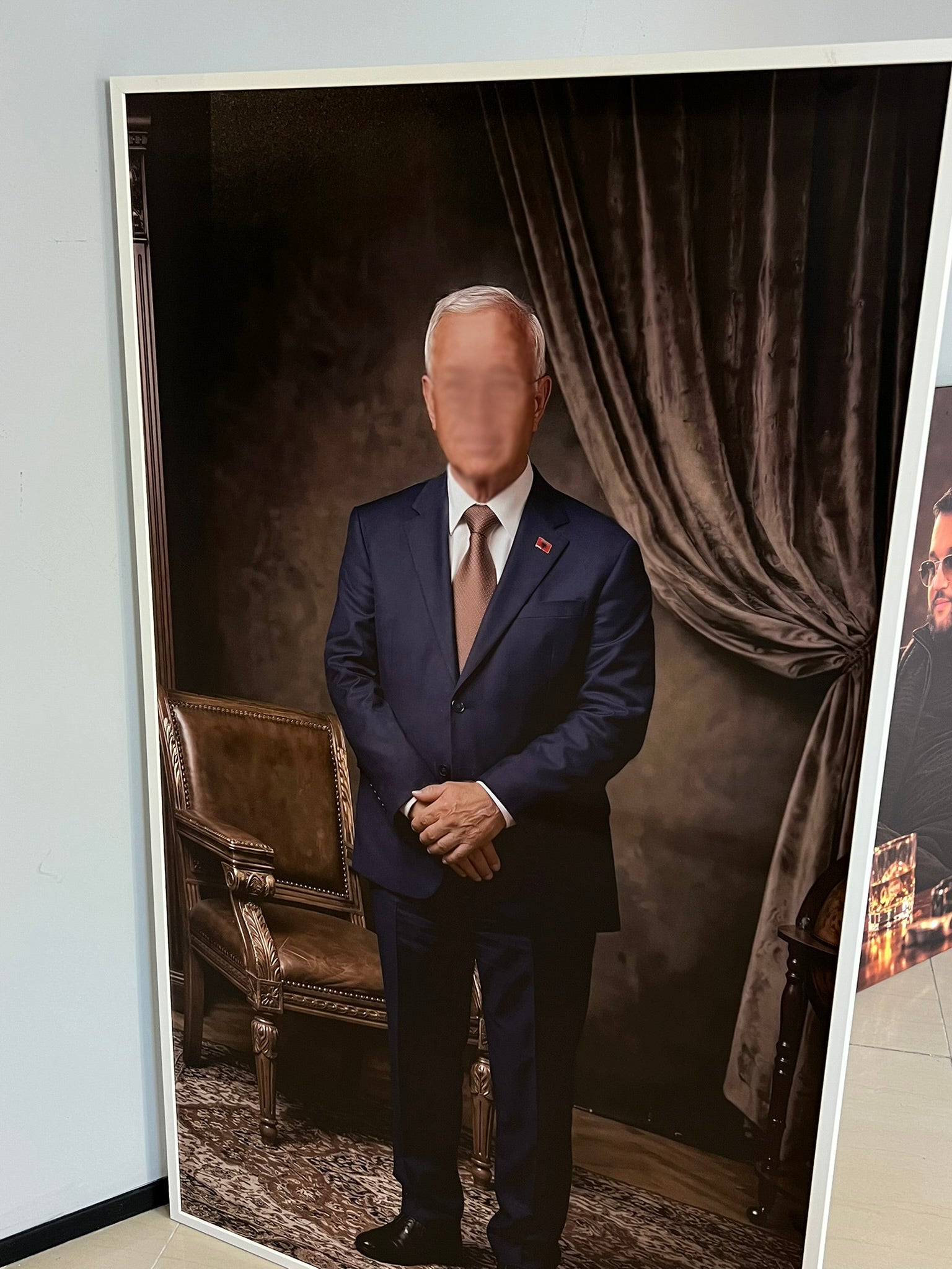 Man in a suit standing in front of a draped curtain with a blurred face