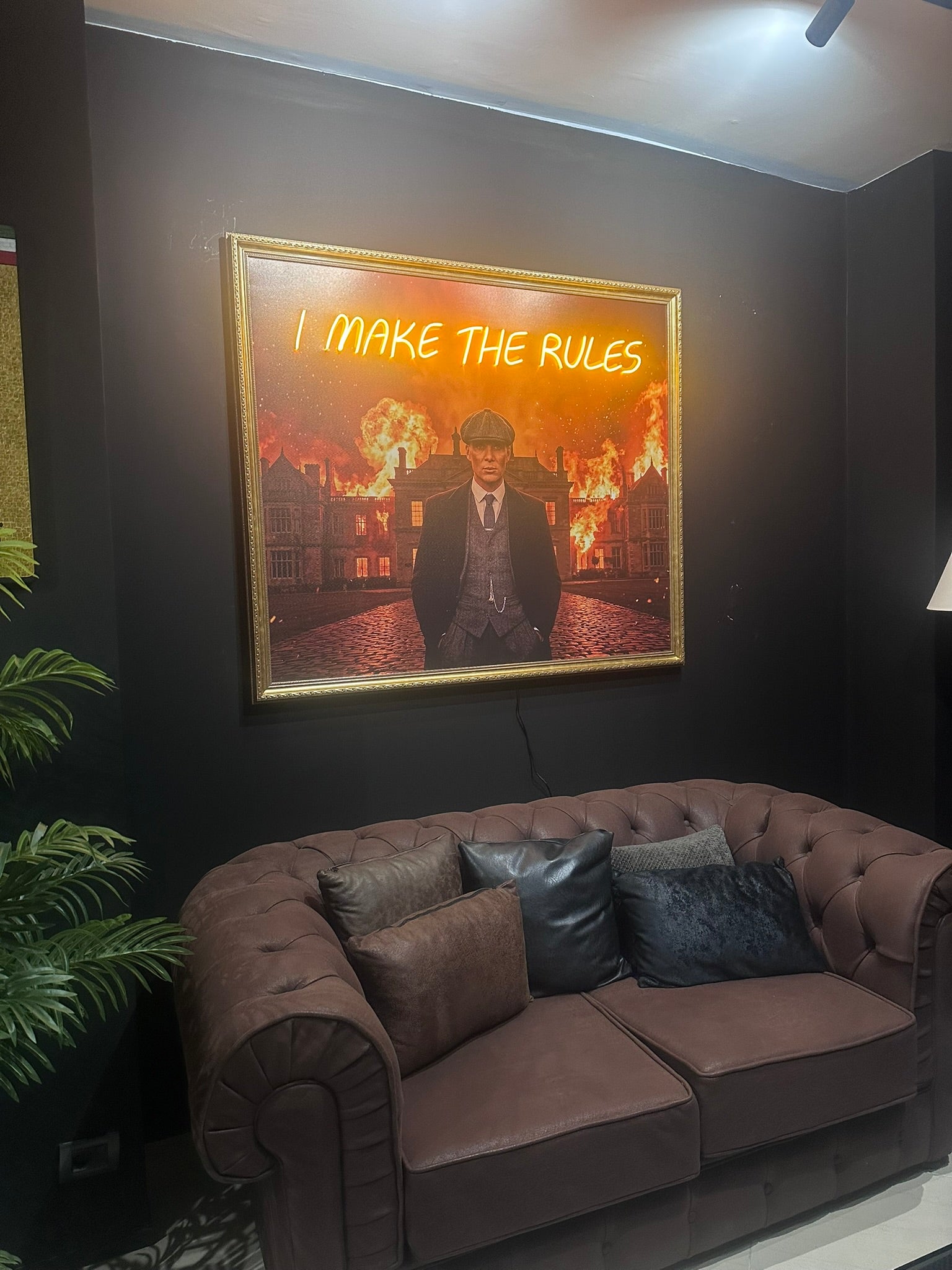 Neon sign with text above a brown sofa in a room.