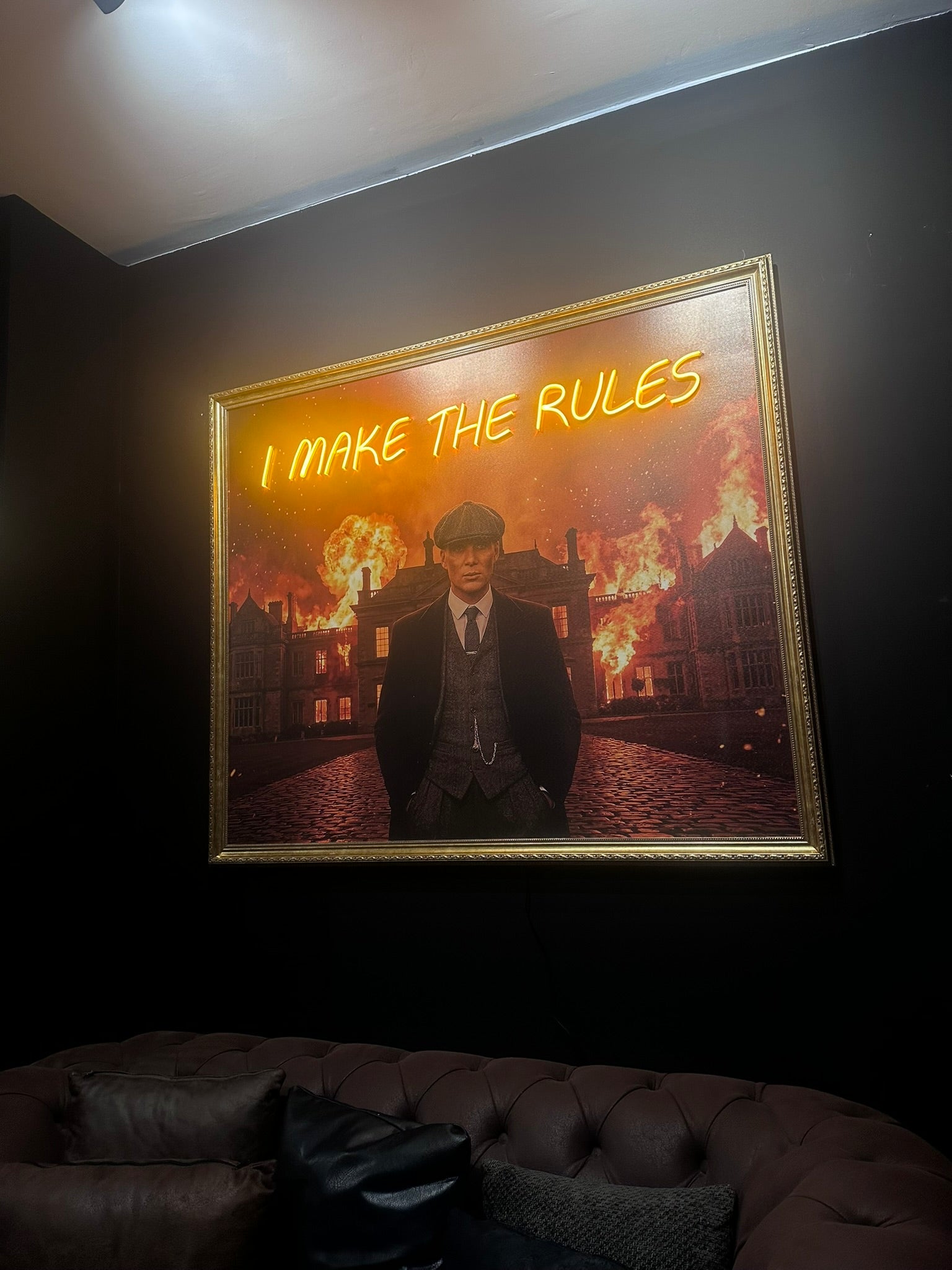 Neon sign with text 'I MAKE THE RULES' in a dimly lit room.