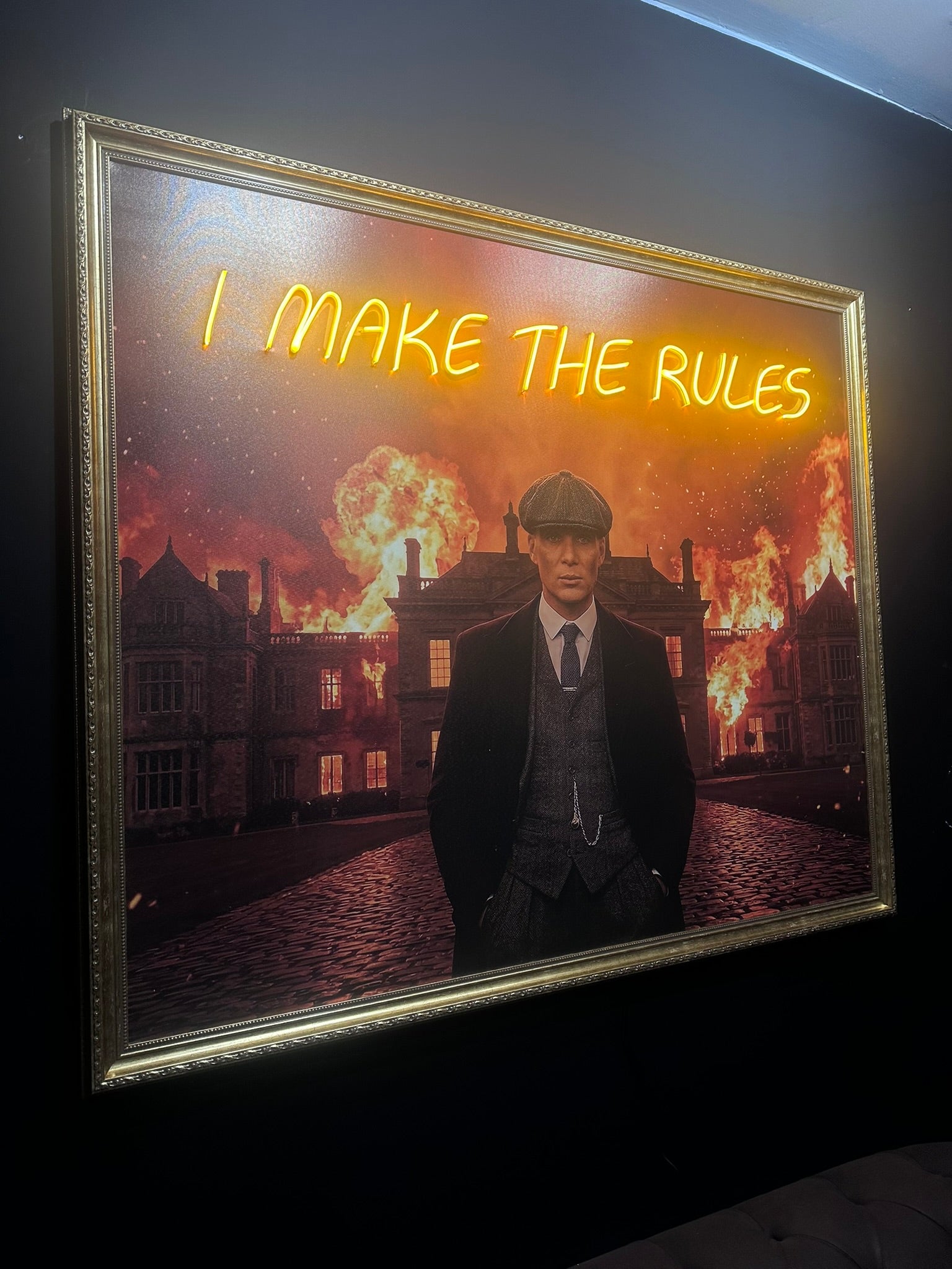 Framed artwork with a man in a suit and tie and the text 'I make the rules' over a fiery background.
