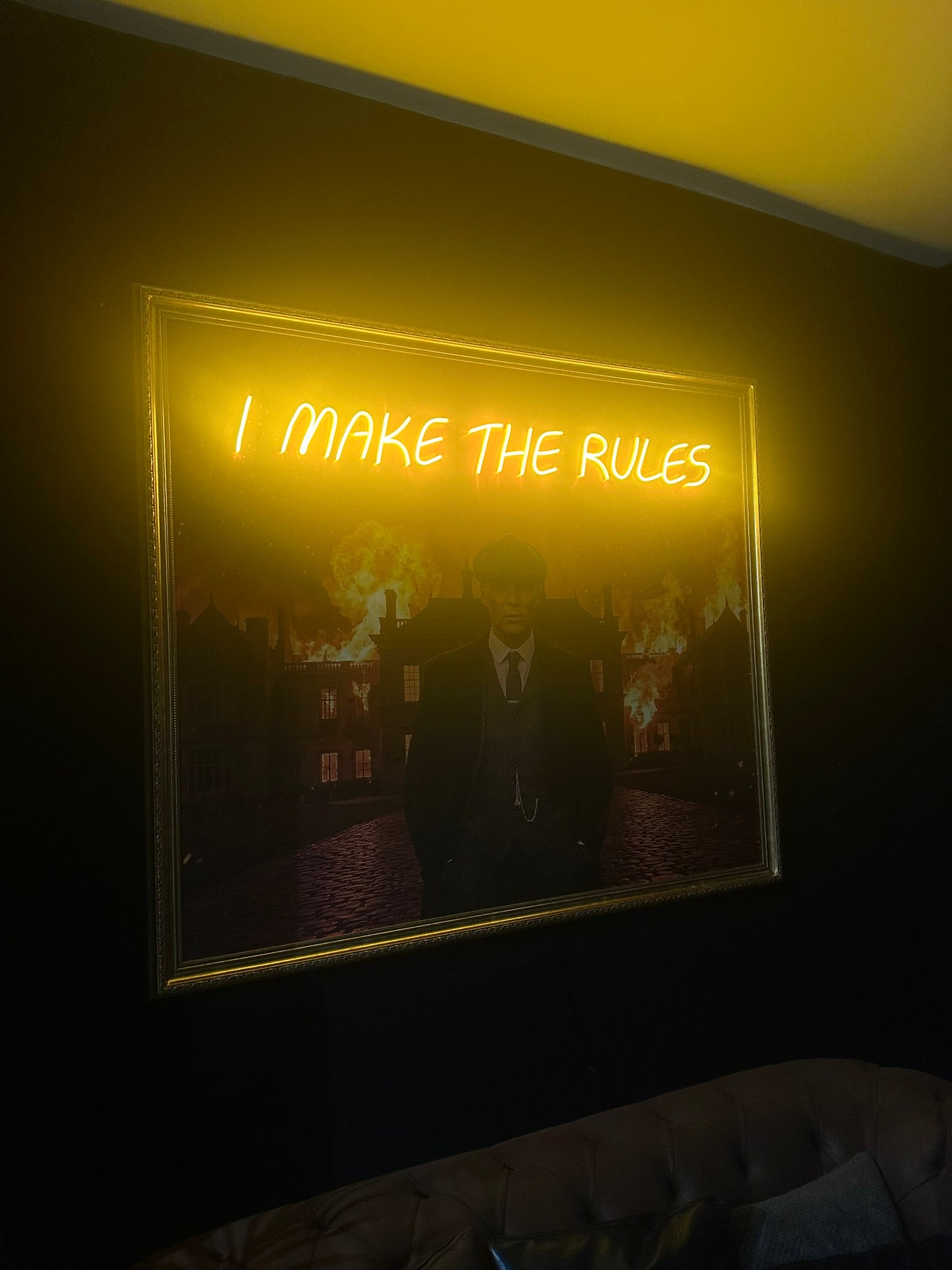 Neon sign with 'I MAKE THE RULES' text in a dark room.