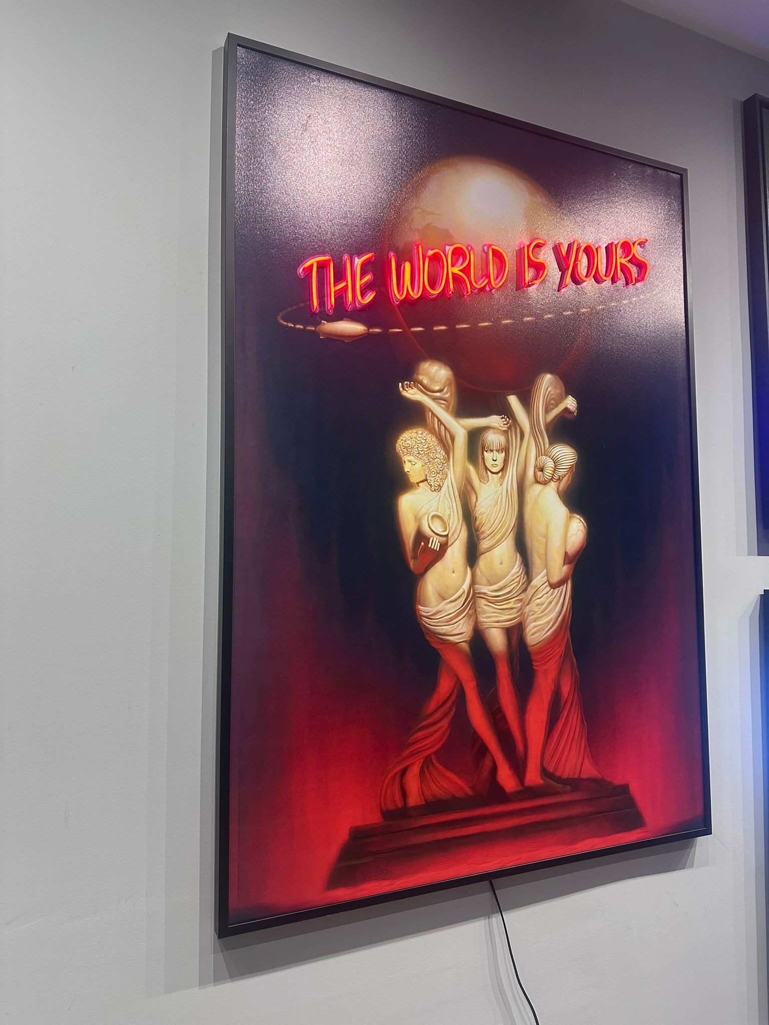 Framed artwork with 'The World is Yours' text and two figures on a red background.