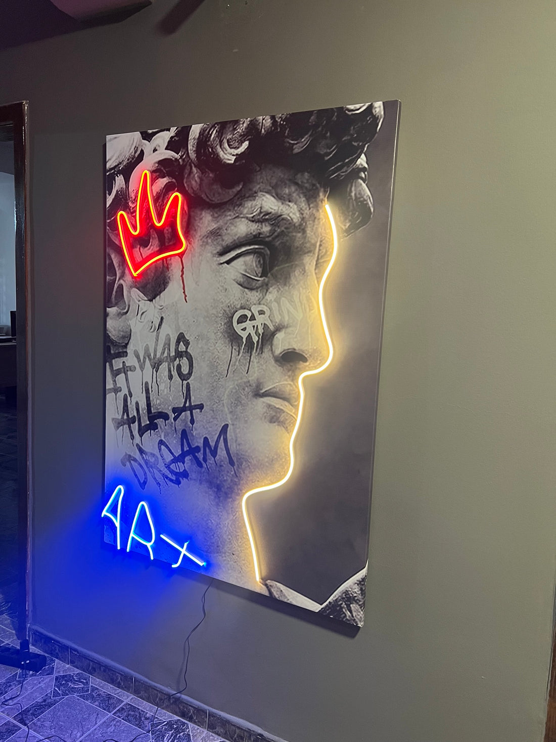 Neon art piece with a stylized face and text on a dark background