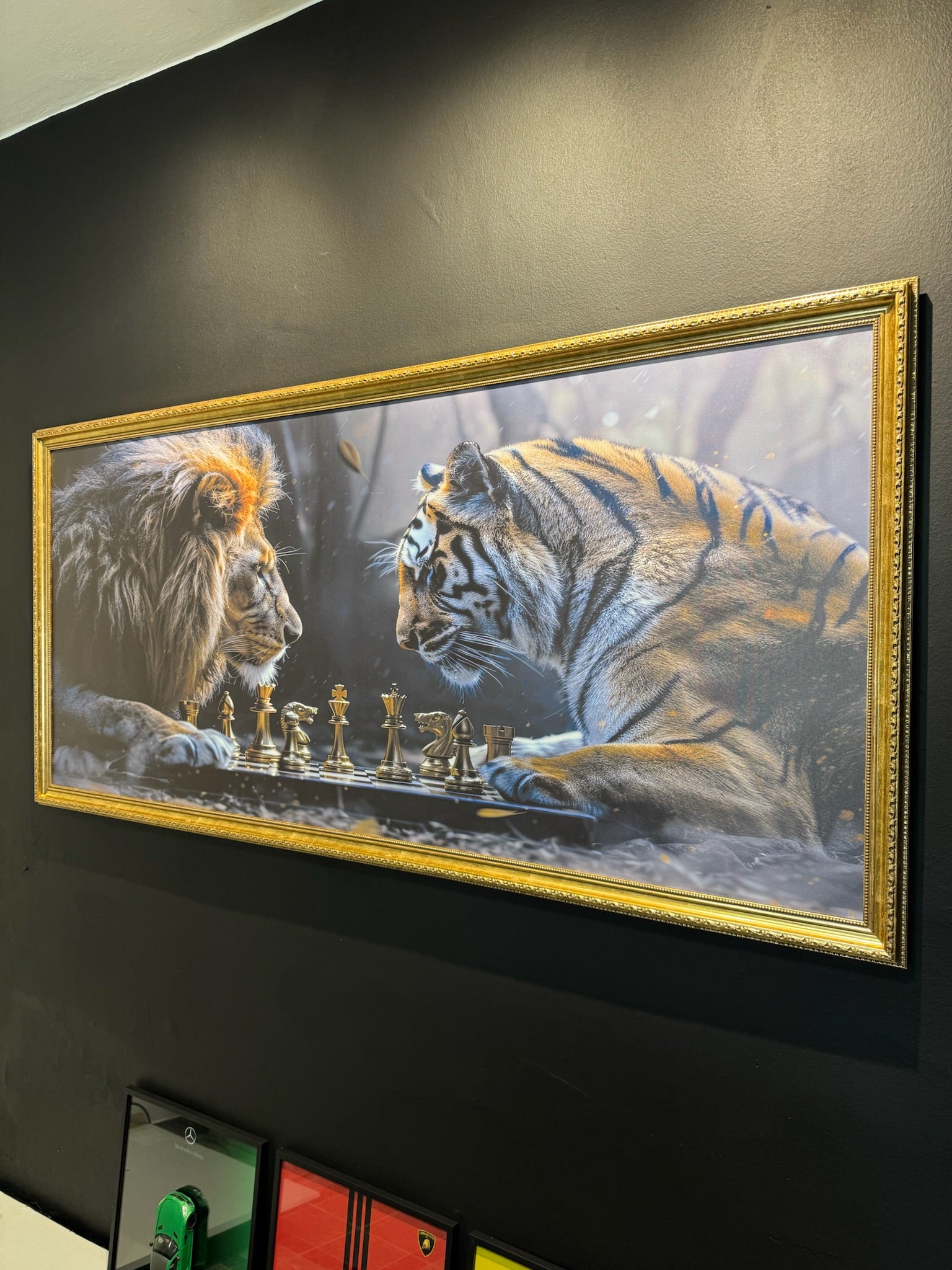 Framed artwork of a lion and tiger playing chess on a dark wall.