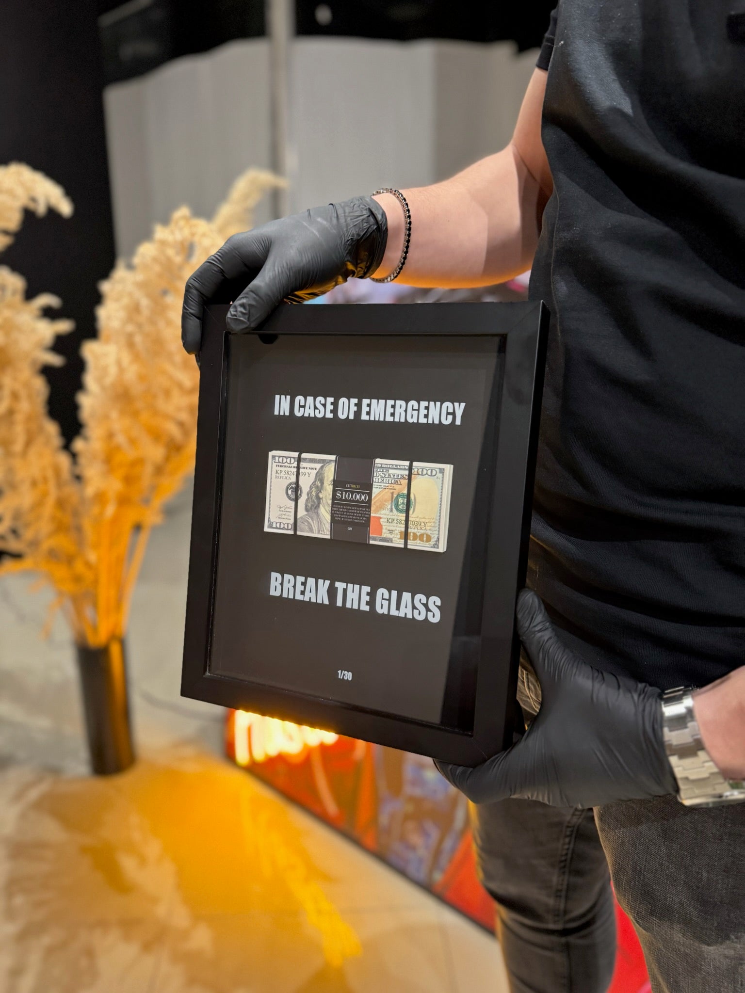 Person holding a framed emergency instruction sign with text and images.