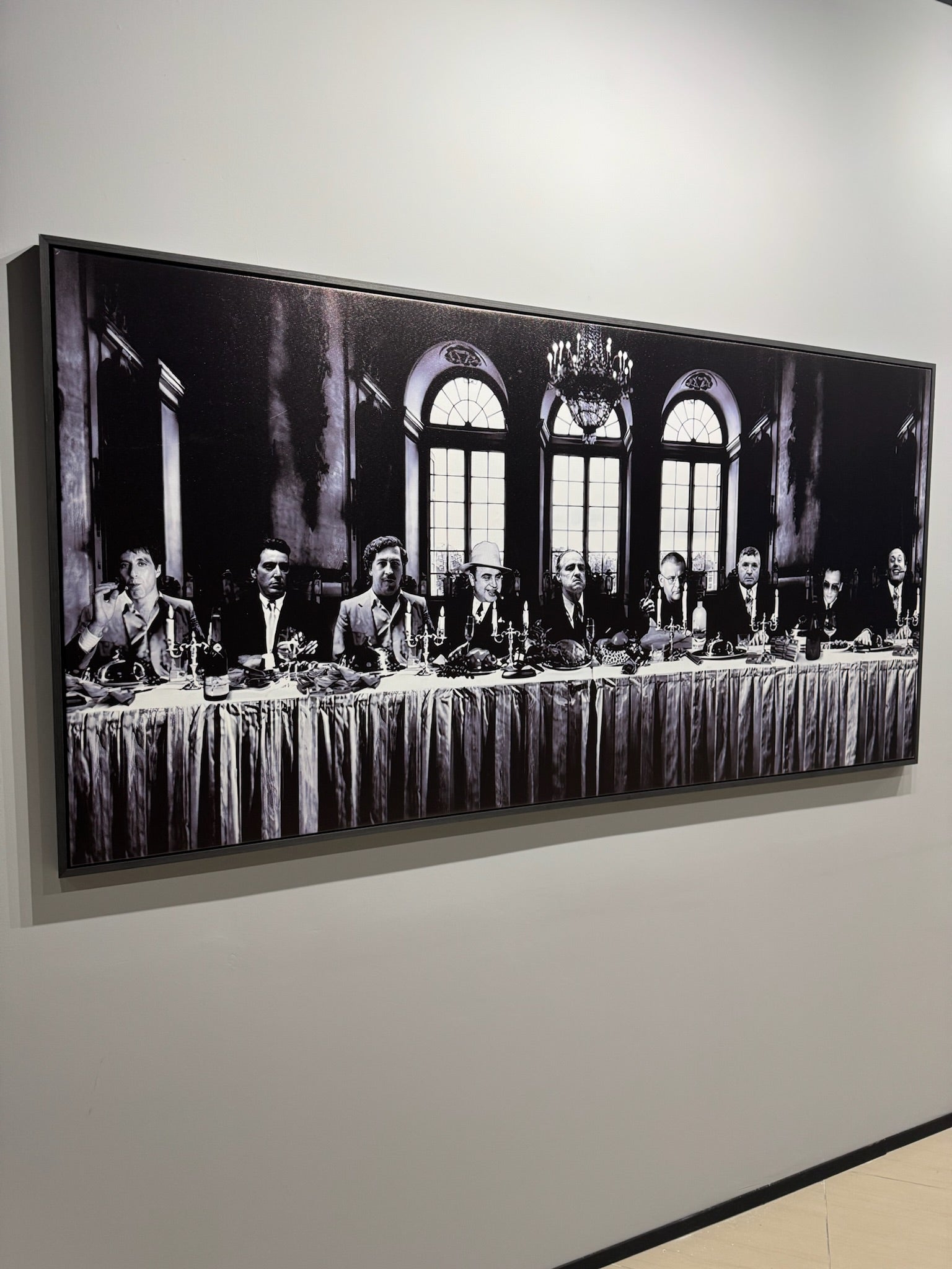 Framed black and white photograph of a formal event with multiple people at a long table.