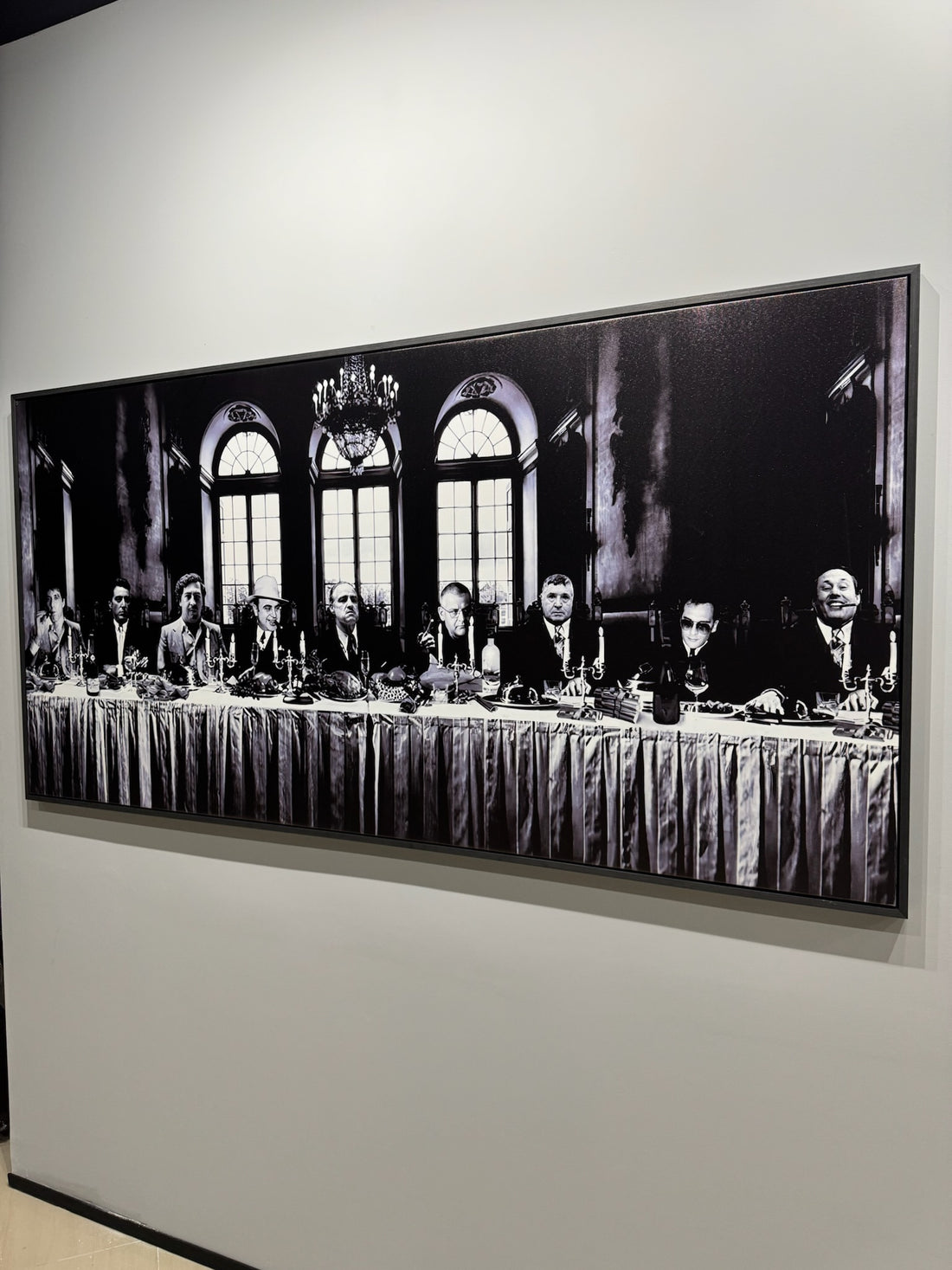 Framed black and white photograph of a formal event with multiple people at a long table.