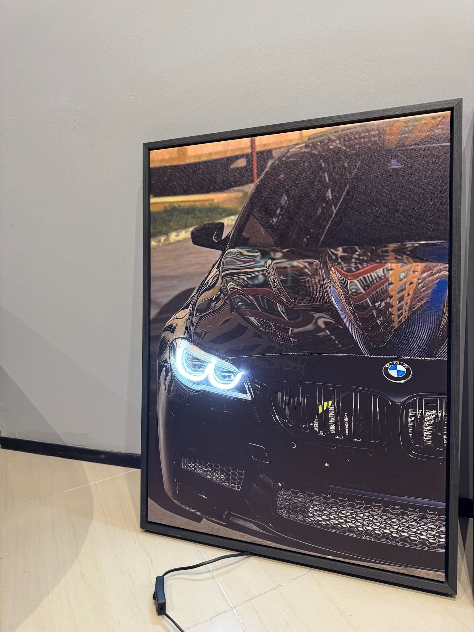 Framed picture of a BMW car on a white wall