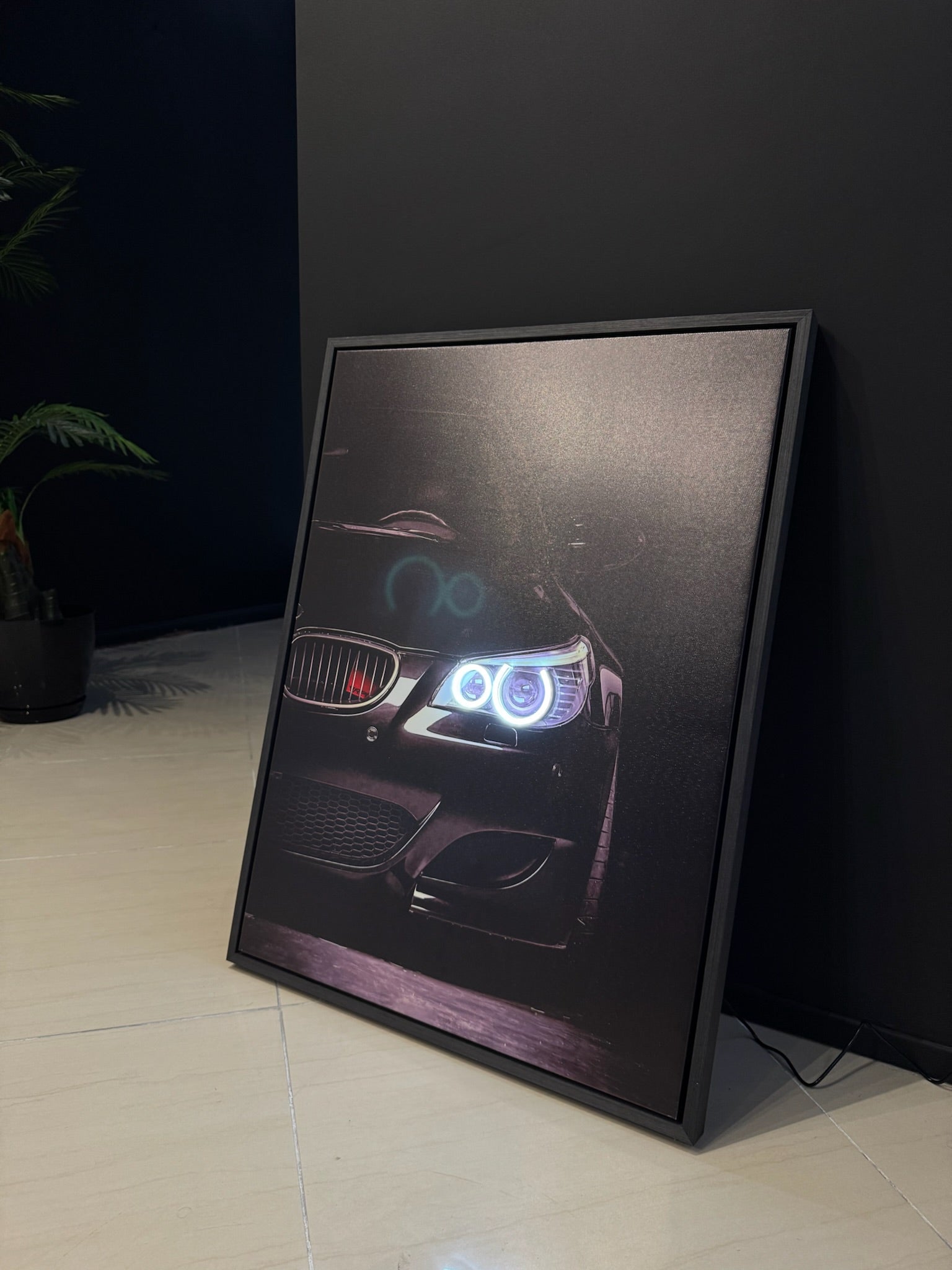 Framed artwork of a car's front grille and headlights on a dark background