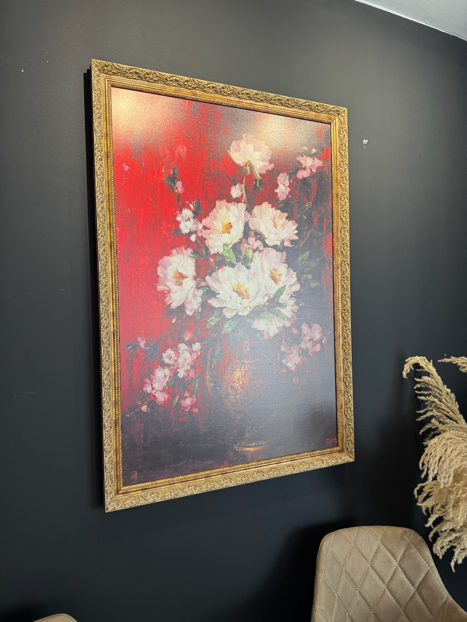 Framed floral painting on a dark wall
