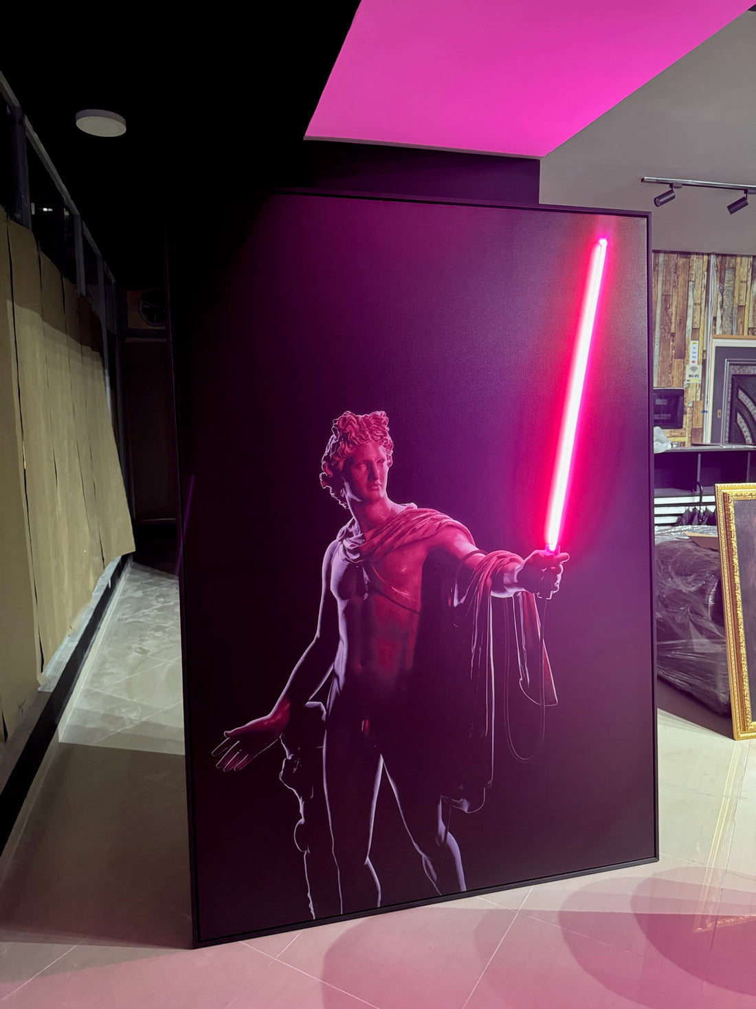 Framed artwork of a figure holding a red lightsaber on a dark background