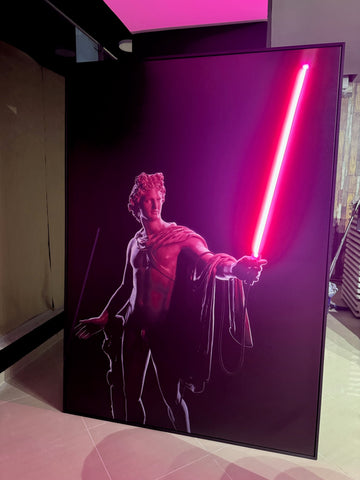 Framed artwork of a figure holding a red lightsaber on a dark background