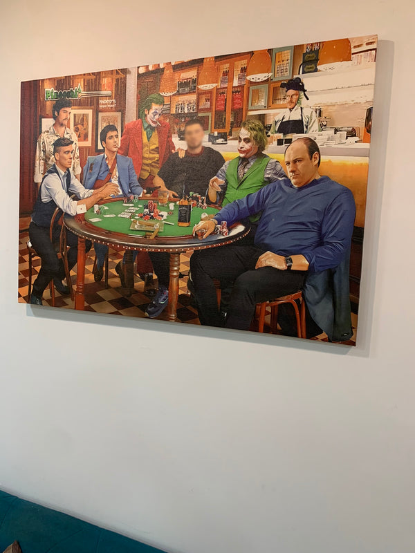 Artistic depiction of people around a table with drinks, framed on a wall.