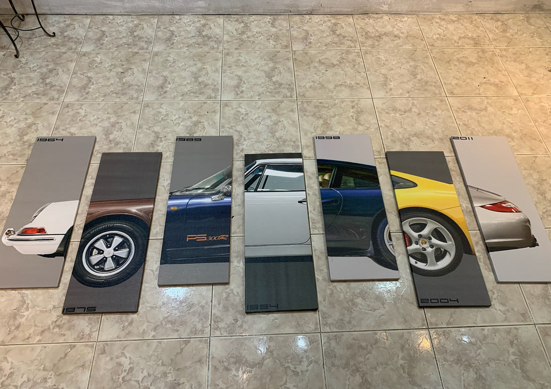 Set of car brochures or posters displayed on a tiled floor.