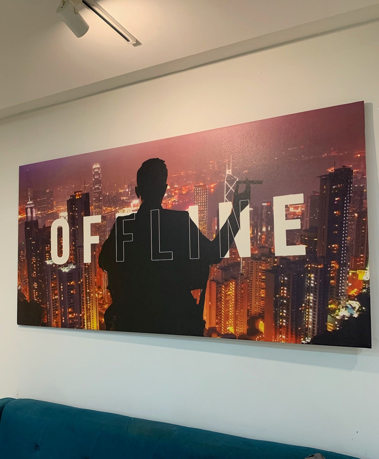 Silhouette of a person against a cityscape with 'OFFLINE' text on a wall.