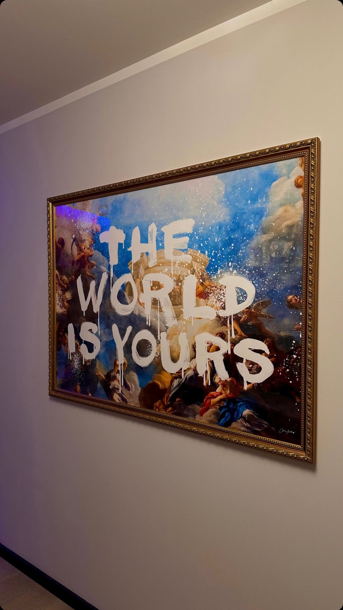 Framed artwork with 'The World is Yours' text on a wall.