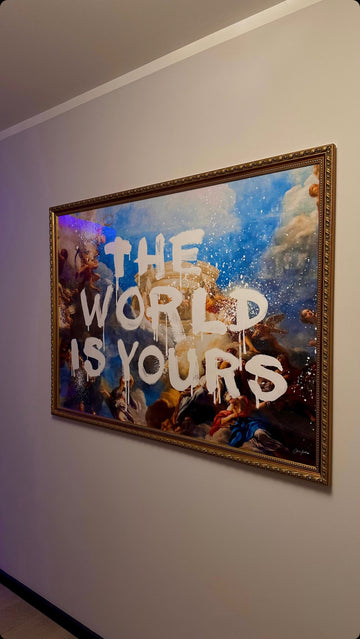 Framed artwork with 'The World is Yours' text on a wall.