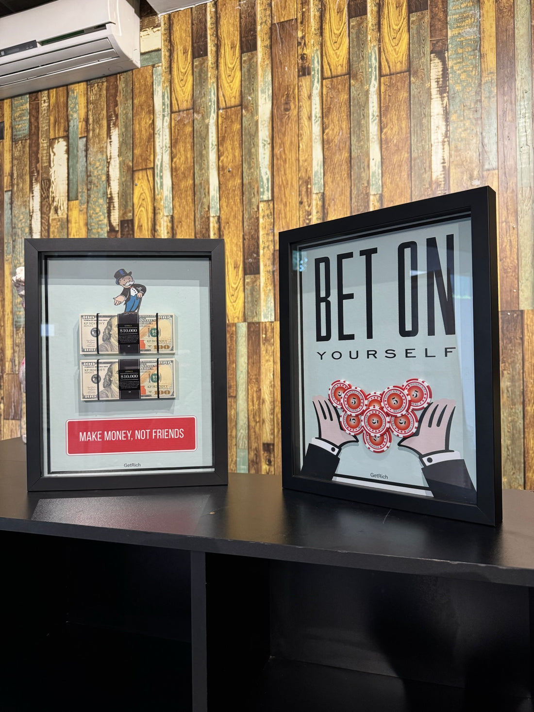Two framed posters on a wooden wall with motivational messages.