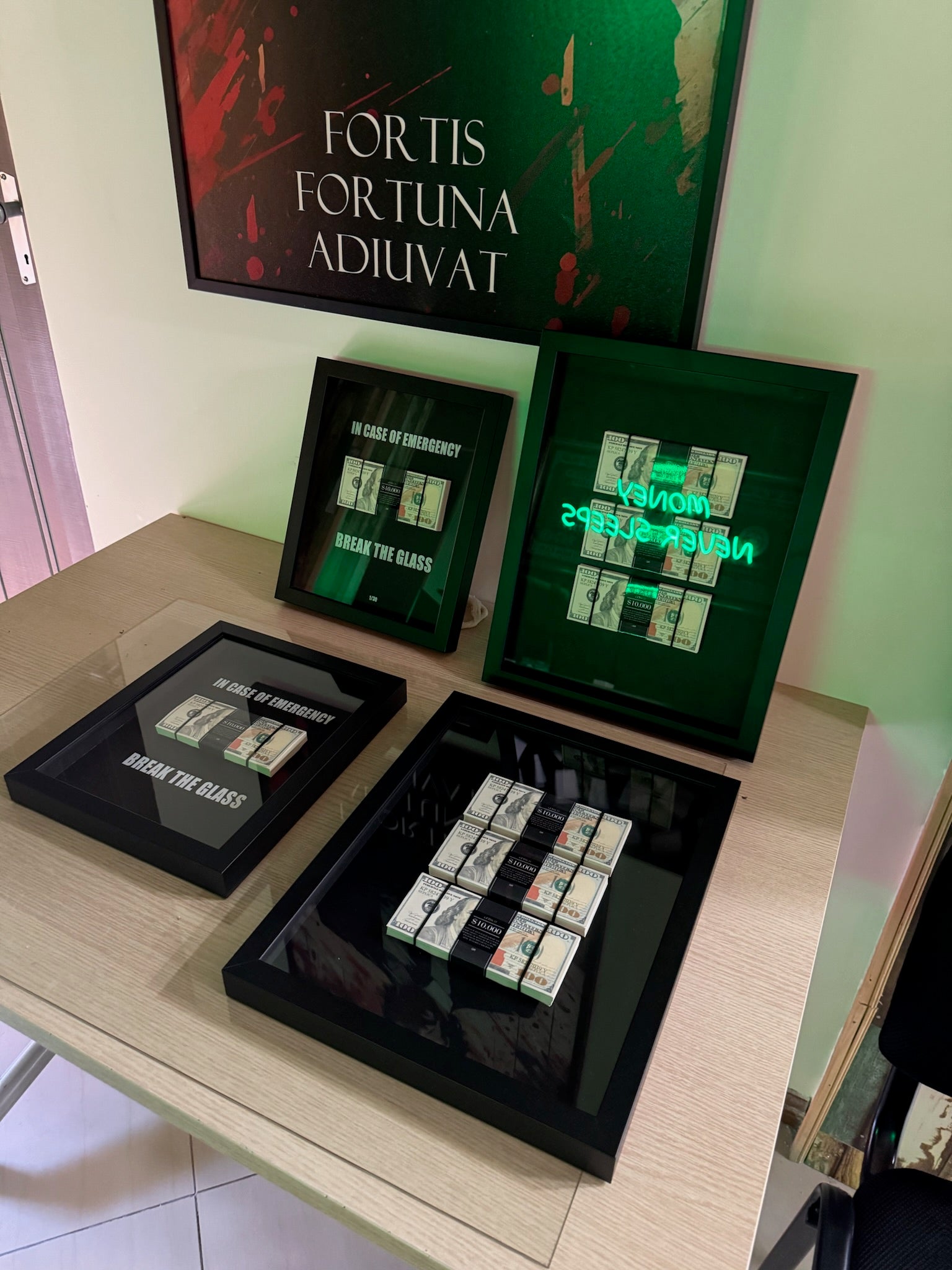 Collection of green and black boxes with 'Fortis Fortuna Adiuvat' text on a table.