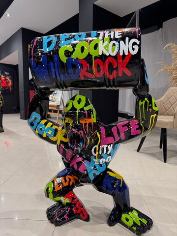 Colorful graffiti gorilla statue holding industrial barrel in modern luxury showroom