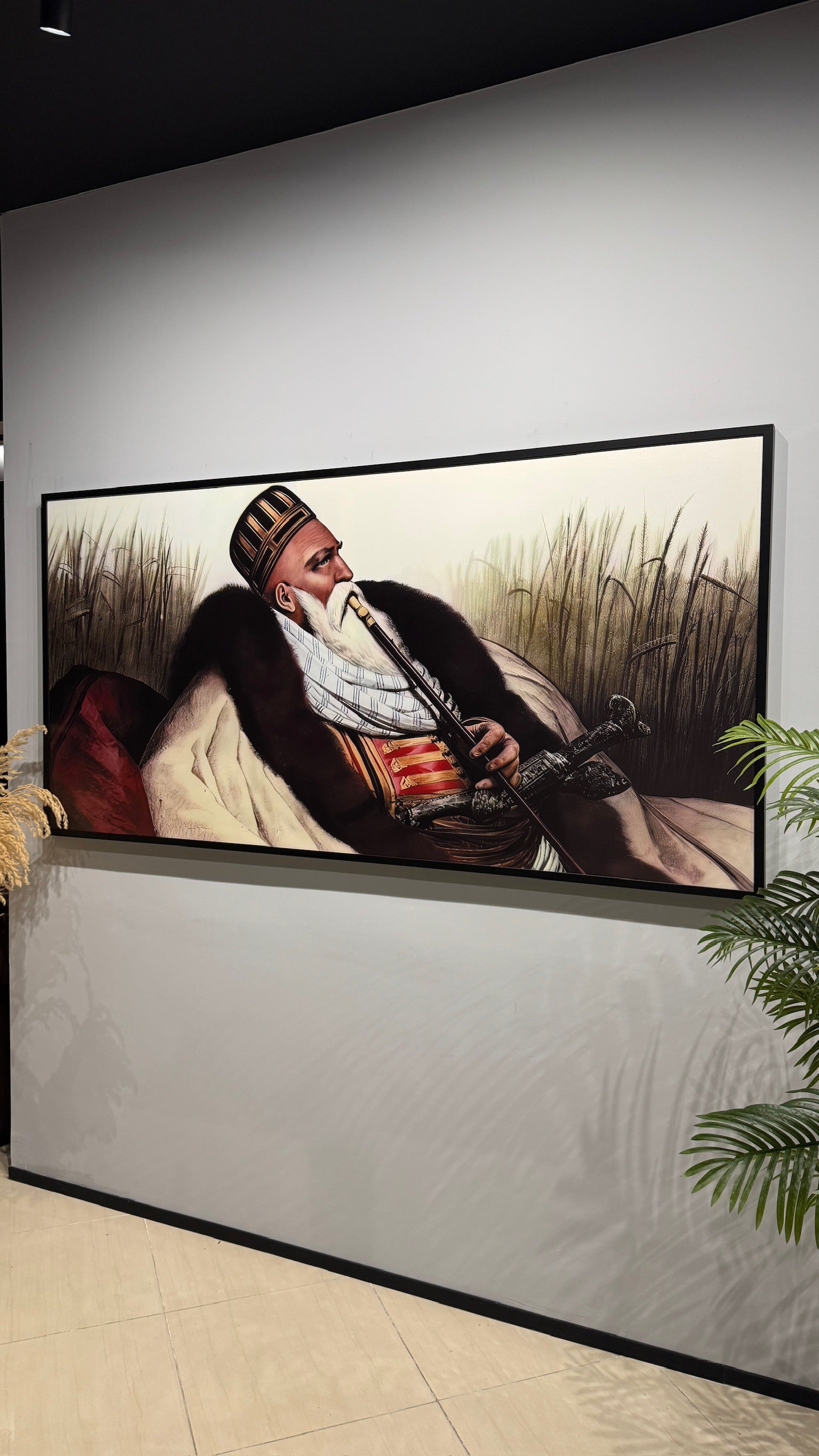 Ali Pasha. Framed artwork of a person playing a wind instrument on a wall.
