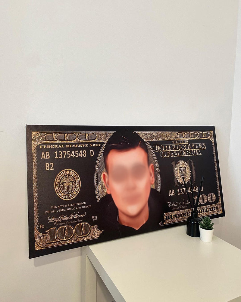 Large decorative item resembling a $100 bill with a blurred face on a white surface.