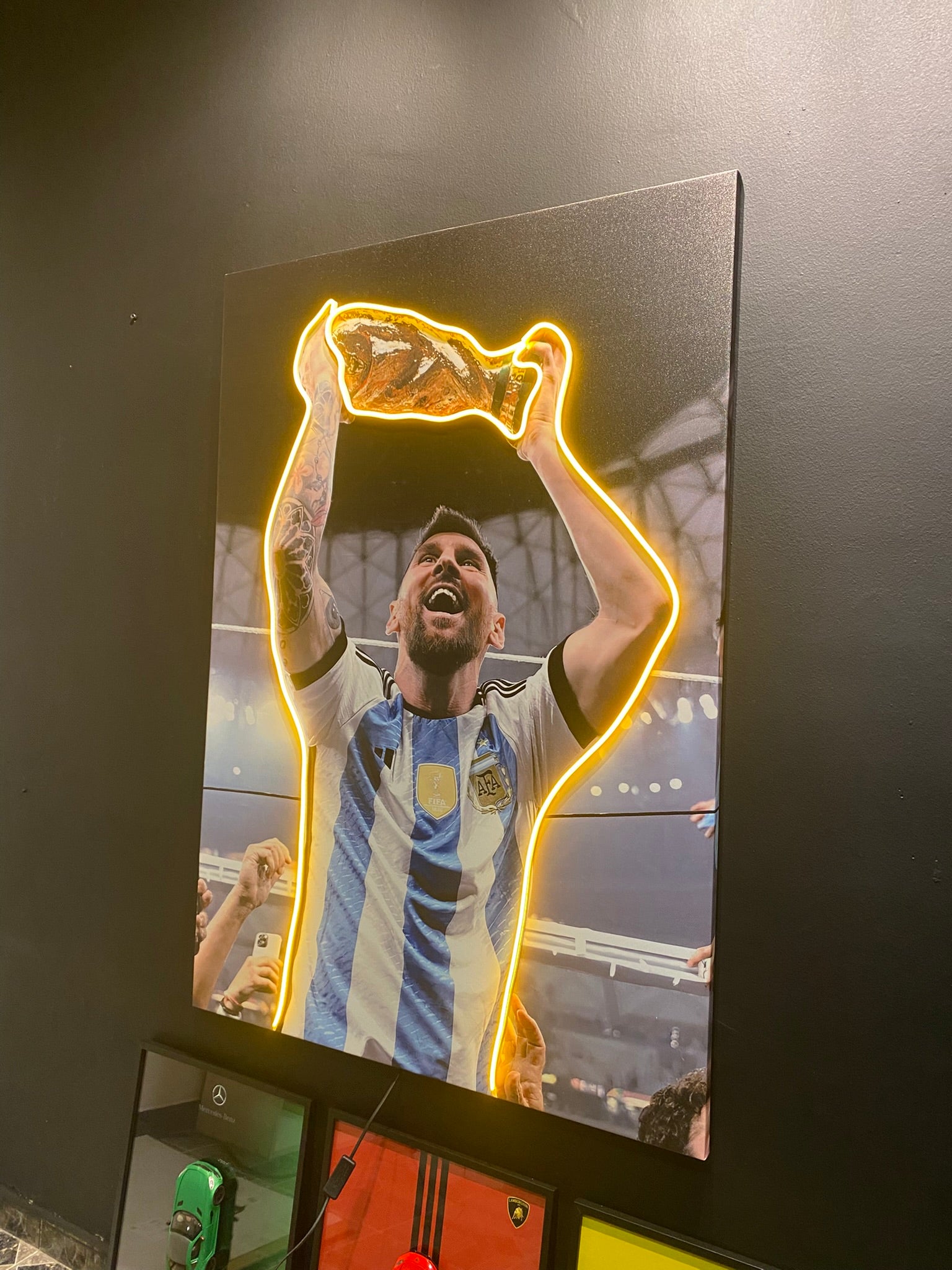 Soccer player holding a trophy with neon yellow outline on a dark background