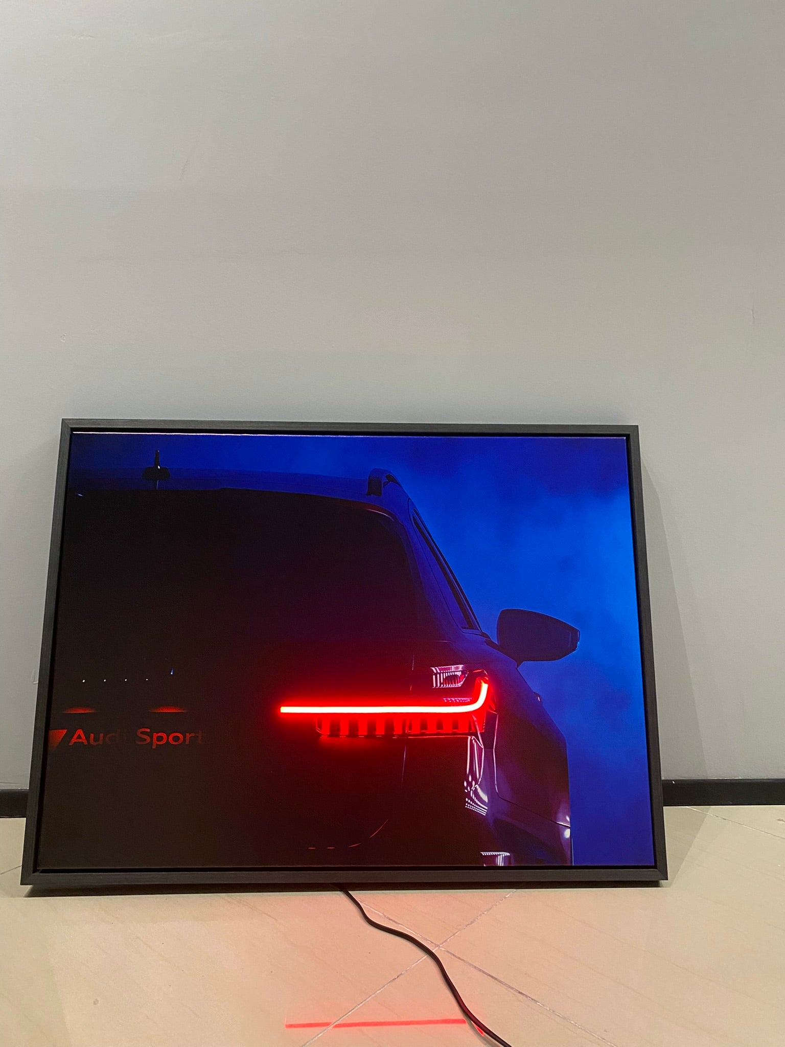 Car advertisement on a screen with a red light effect