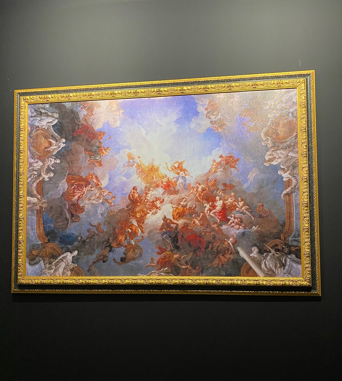 Decorative painting with gold frame on a dark wall