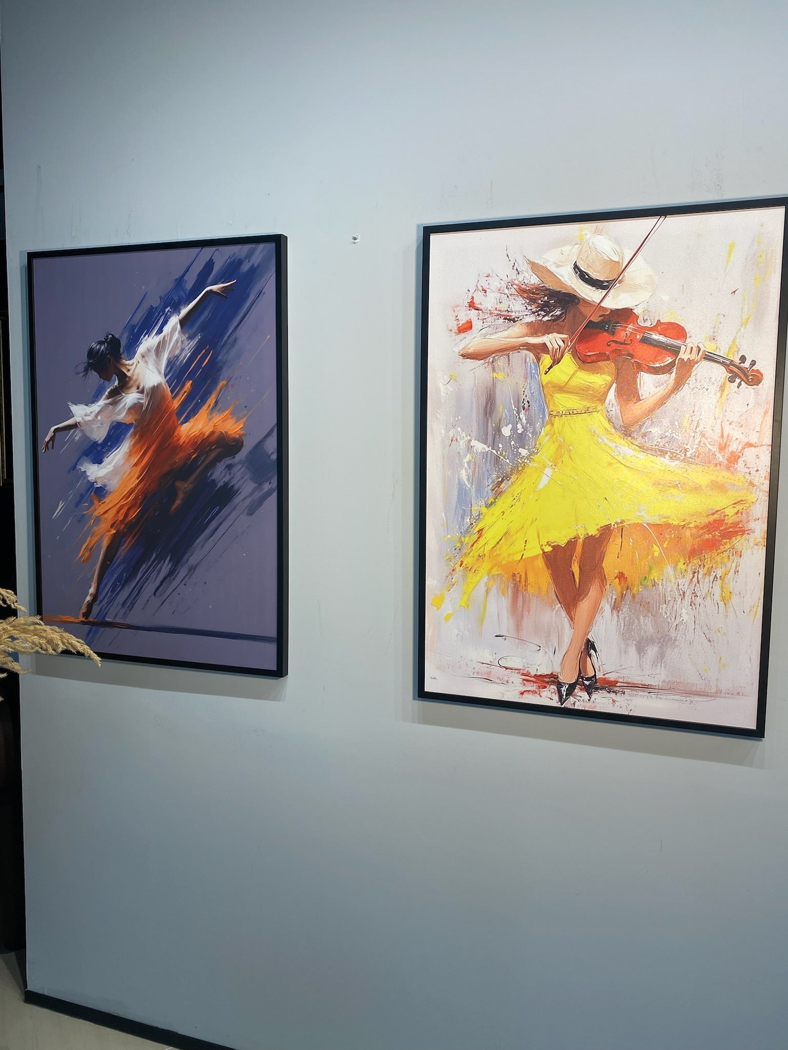Two framed paintings of dancers on a wall.