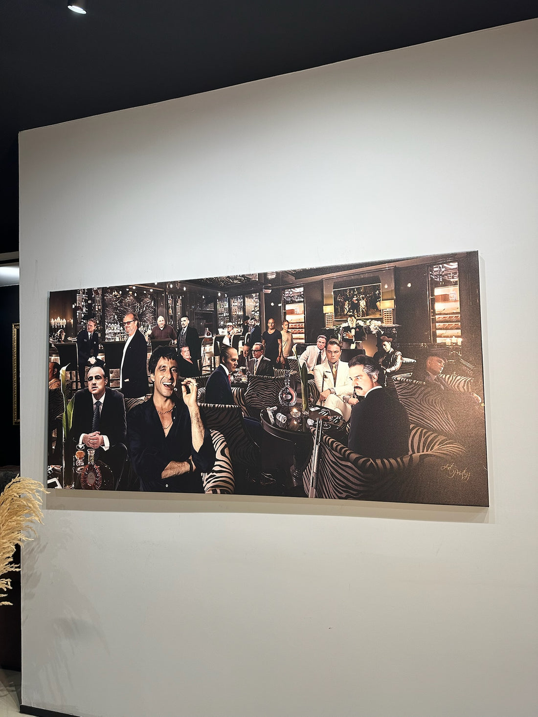 Large black and white photograph of a group of people in a room on a wall.