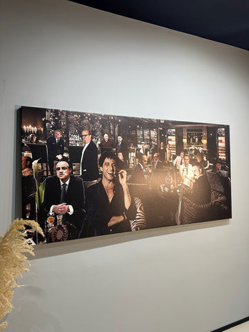 Large black and white photograph of a group of people in a room on a wall.