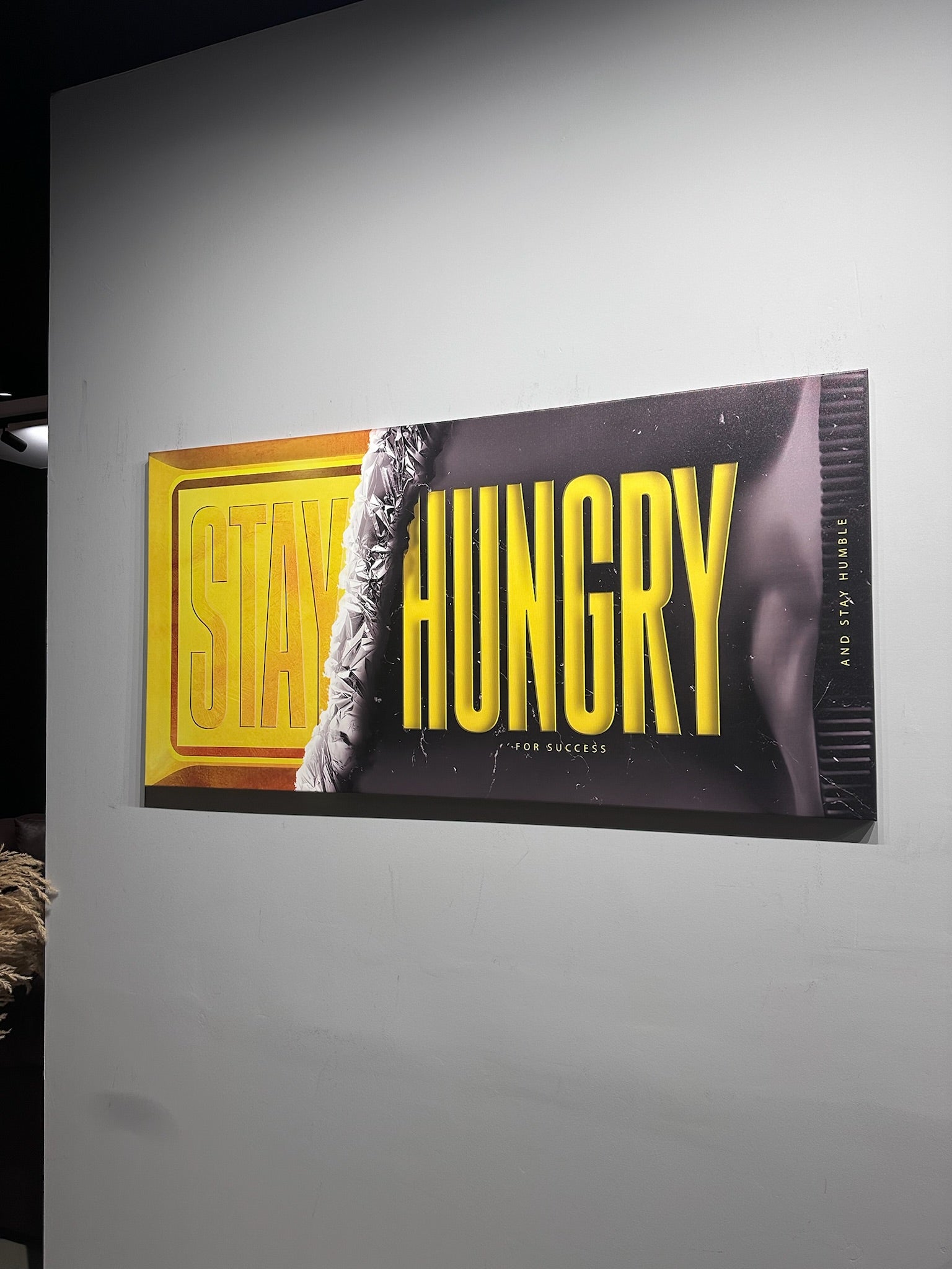 Motivational poster with 'Stay Hungry' text on a gray wall
