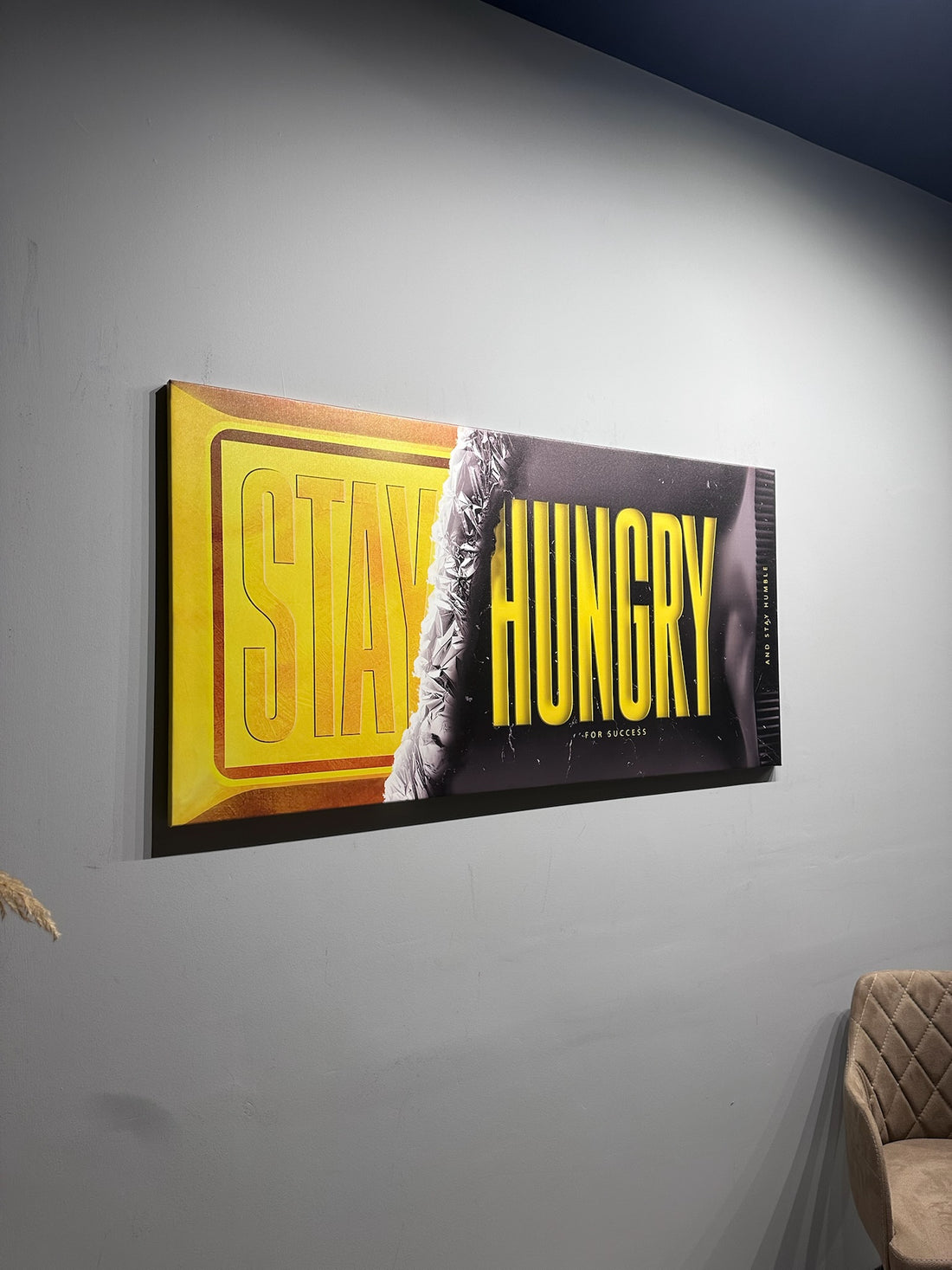 Framed artwork with 'Stay Hungry' text on a gray wall.
