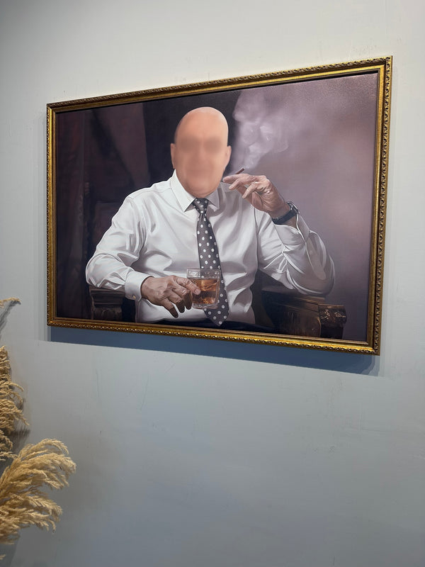 Framed picture of a man smoking a cigar and holding a glass on a wall.