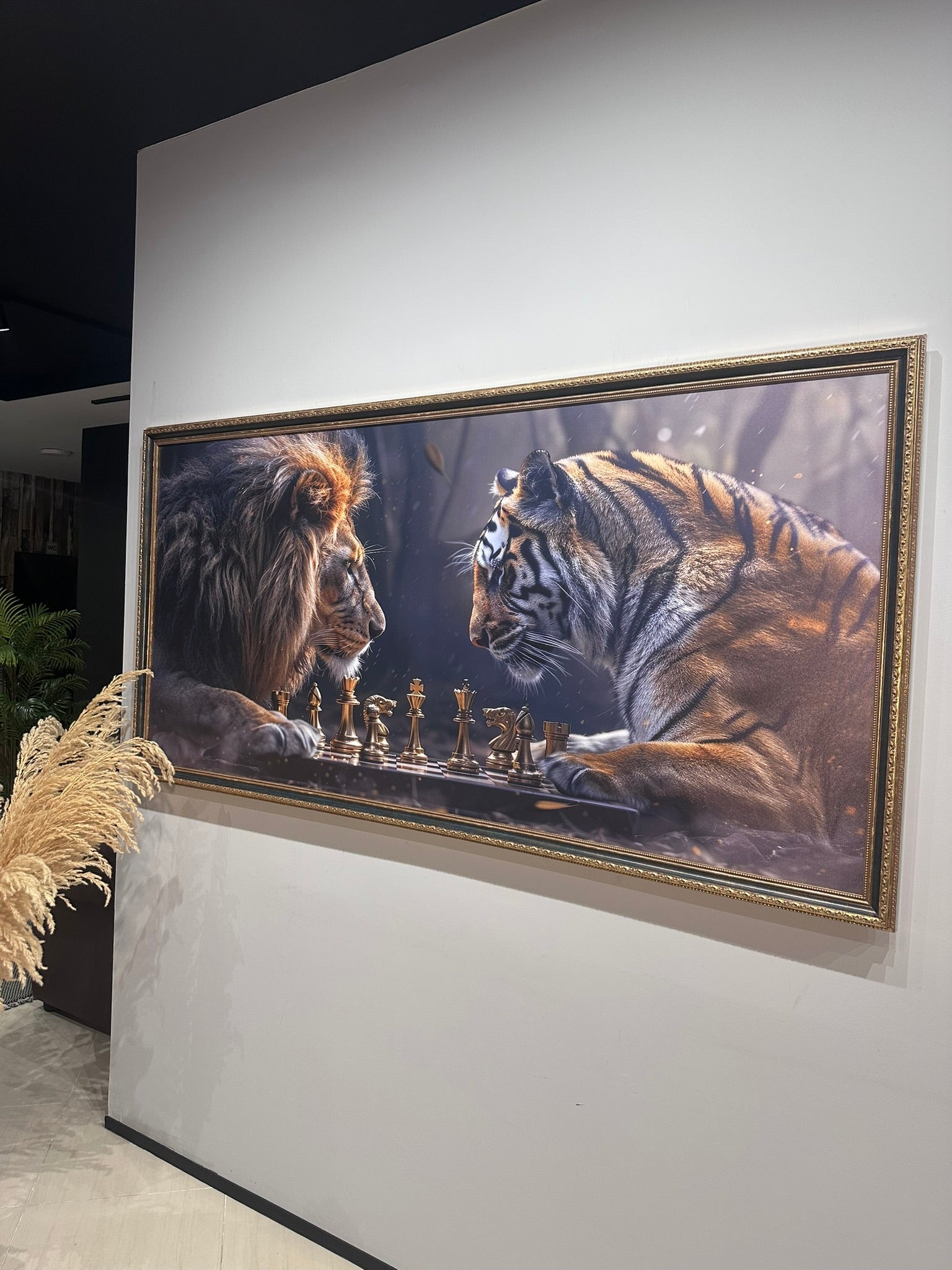 Framed artwork of a lion and tiger playing chess on a wall.