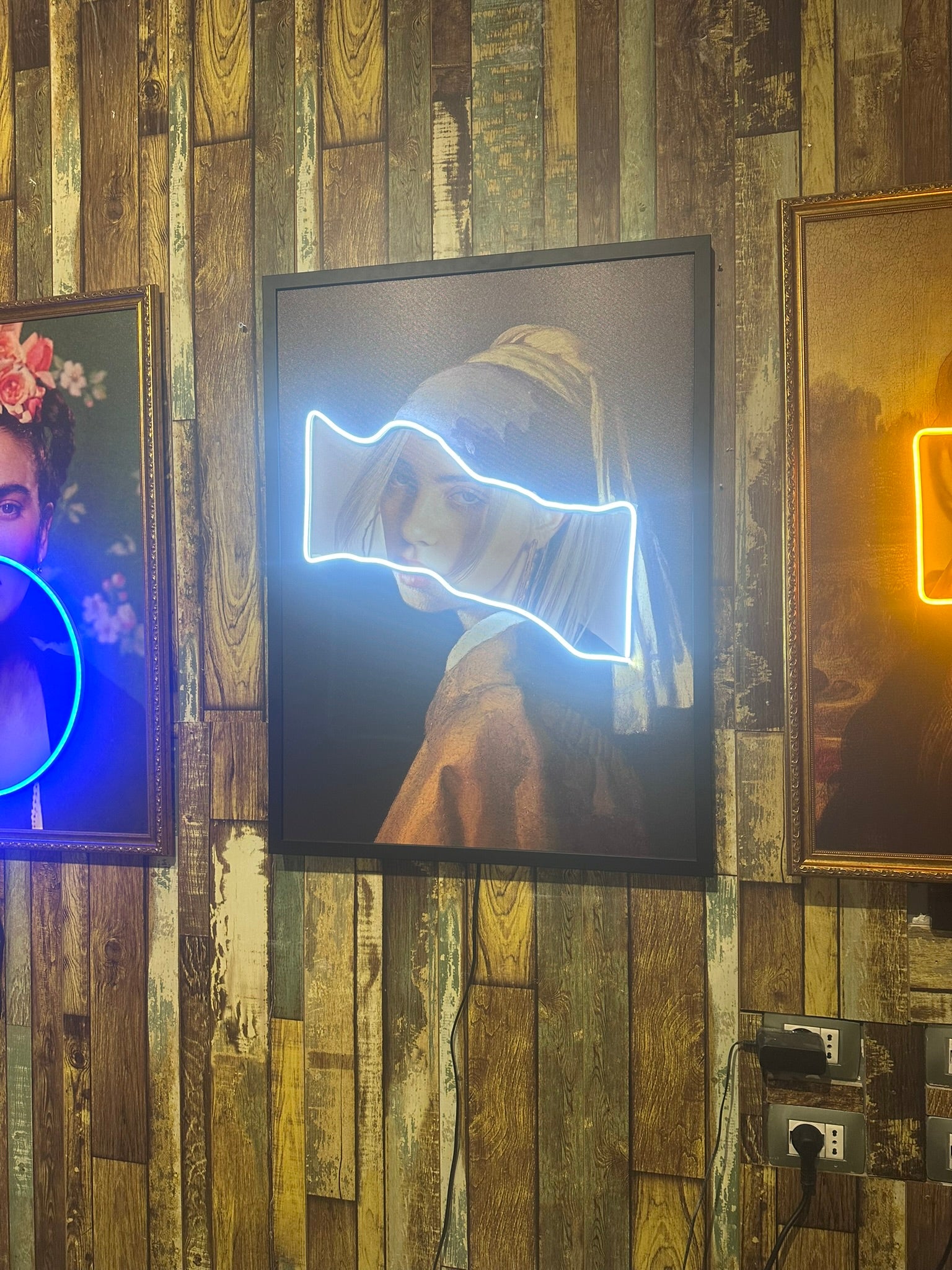 Neon-lit art pieces on a wooden wall