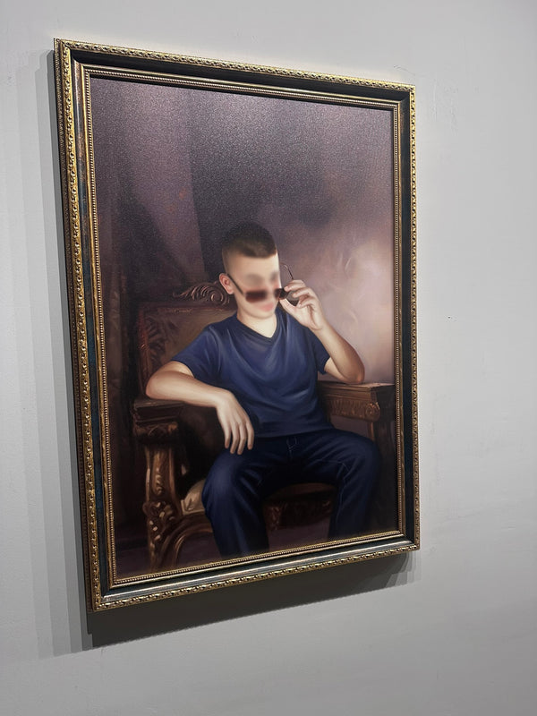 Framed portrait of a person sitting in a chair on a gray wall