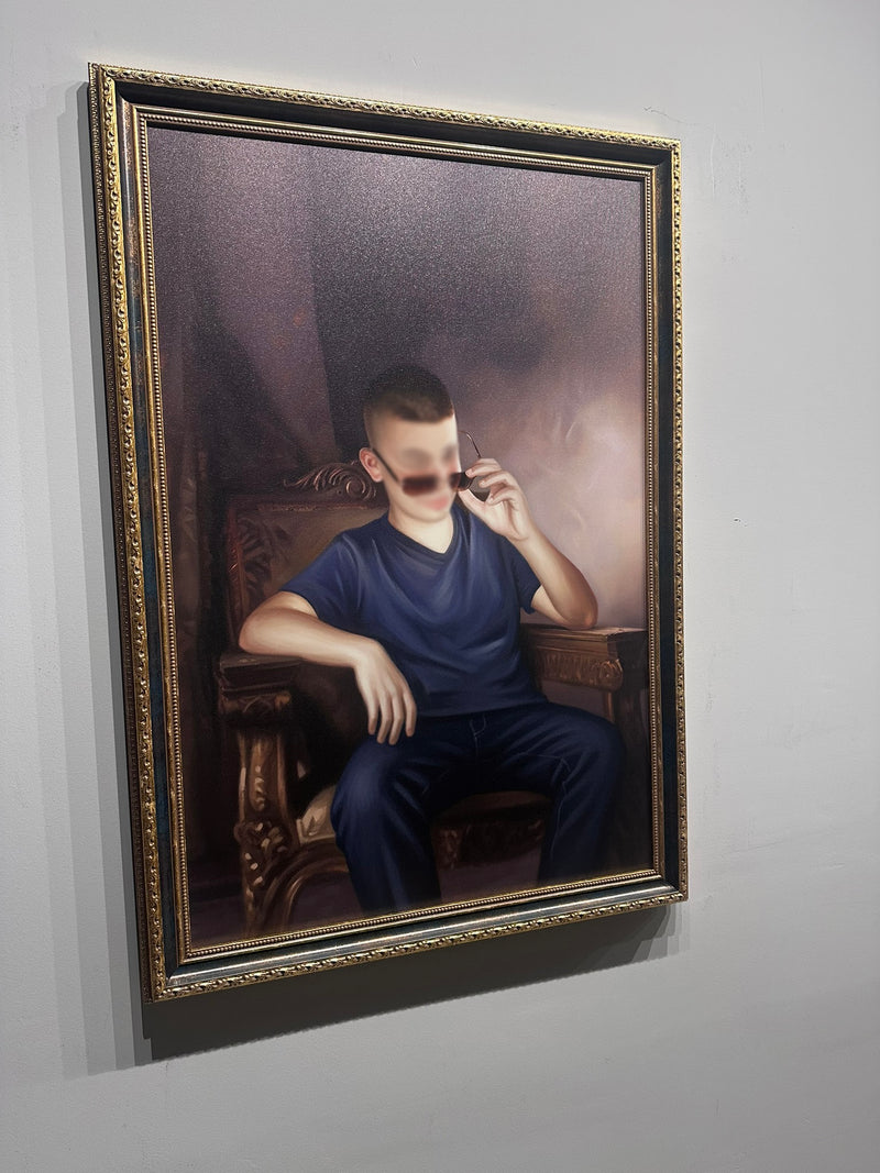 Framed portrait of a person sitting in a chair on a gray wall