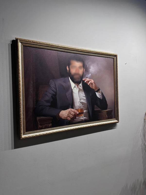 Framed portrait of a man smoking a cigarette and holding a glass on a gray wall.