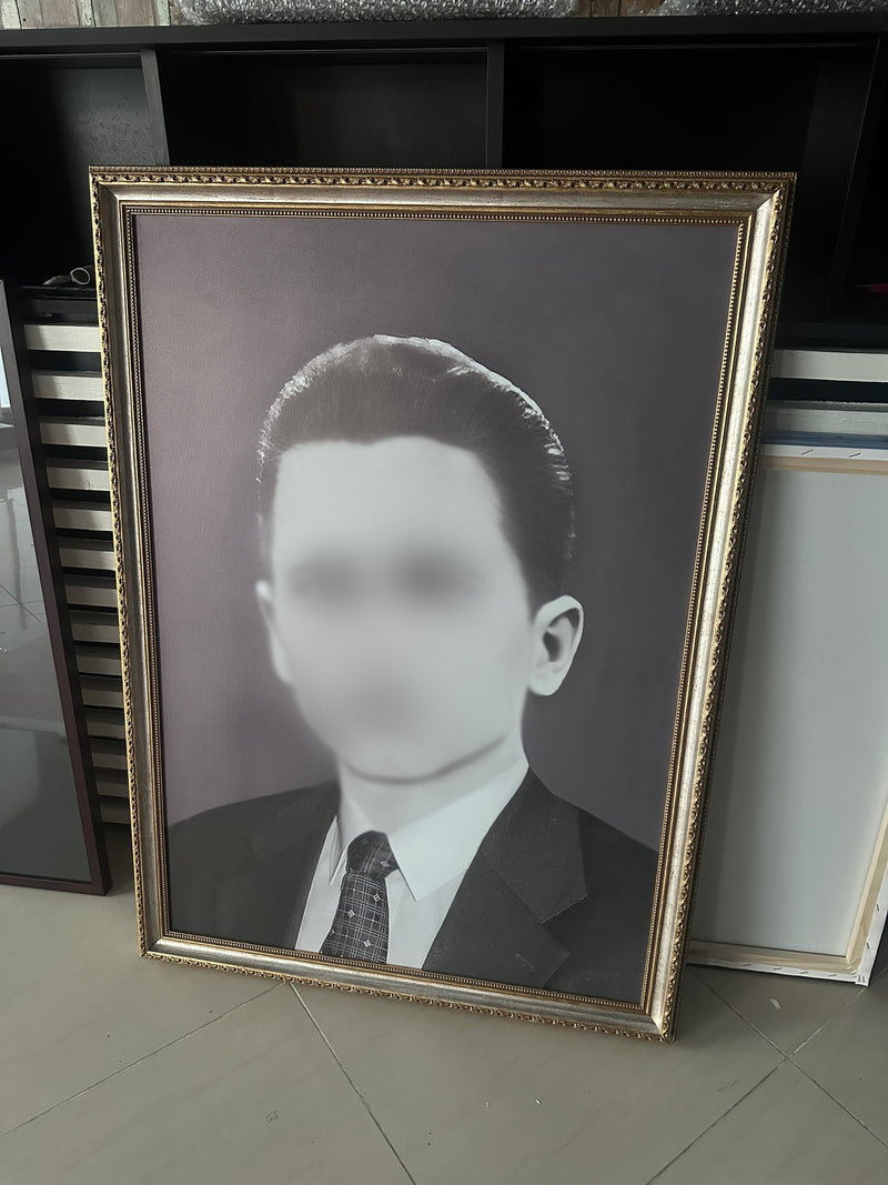 Framed black and white portrait of a man on a tiled floor.