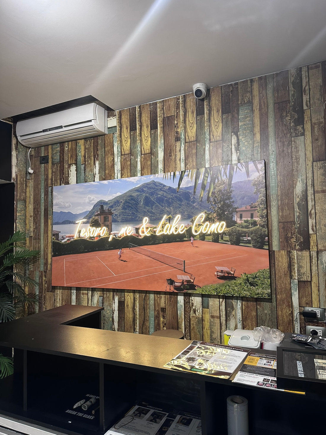 Room interior with a large screen displaying a scenic view of a lake and mountains.