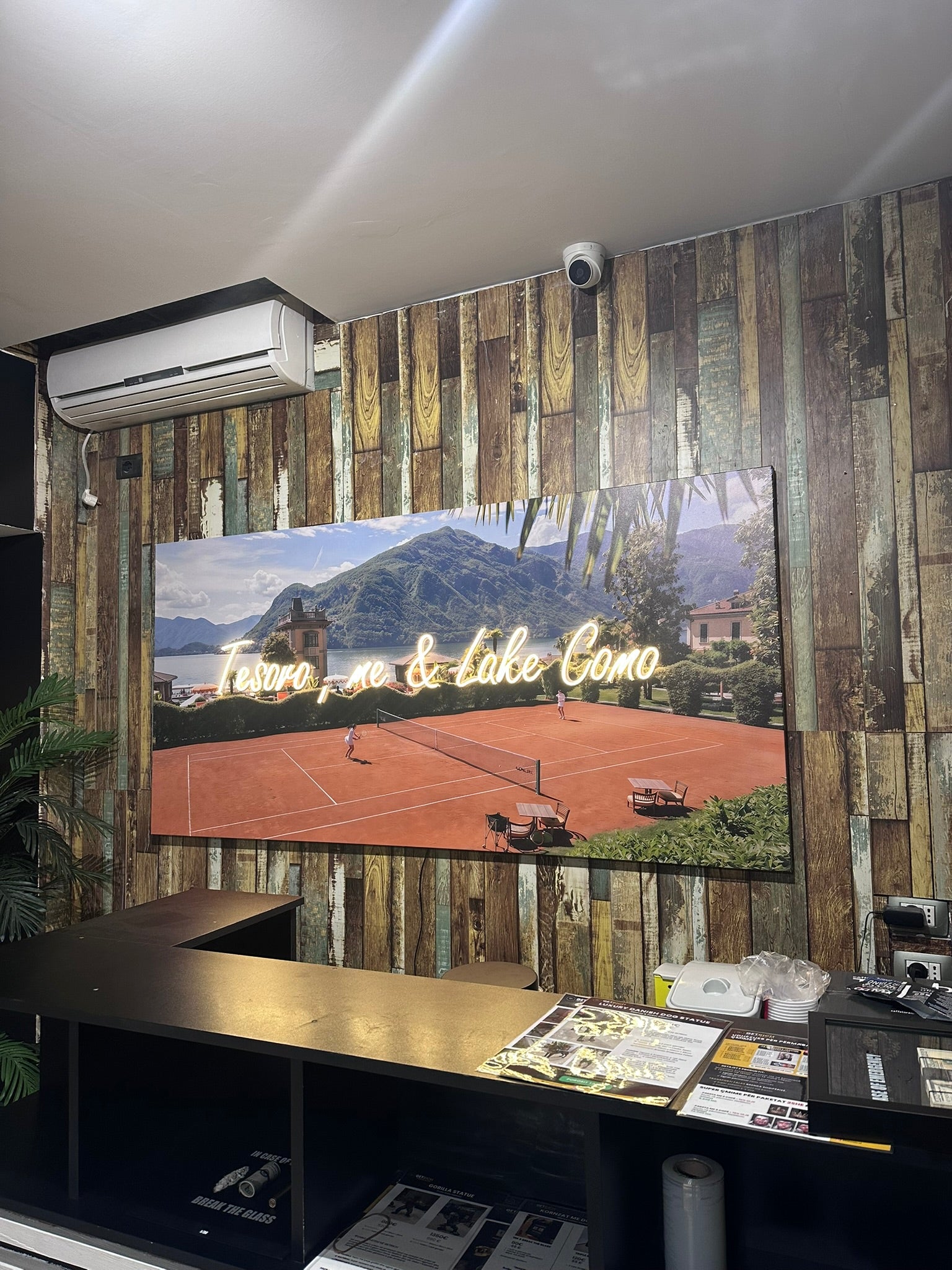 Room interior with a large screen displaying a scenic view of a lake and mountains.