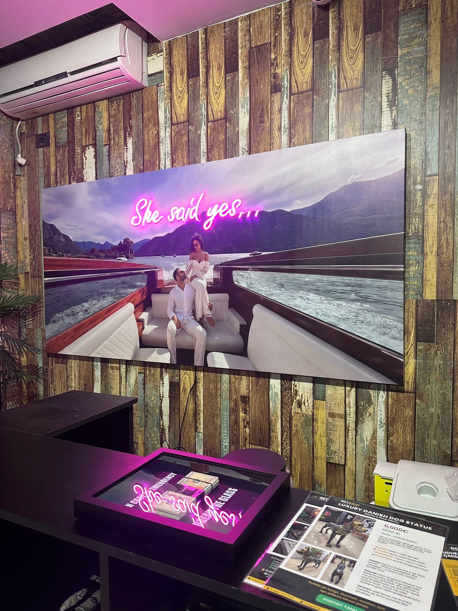 Large screen displaying a romantic scene with text 'She said yes' in a room with wooden walls.