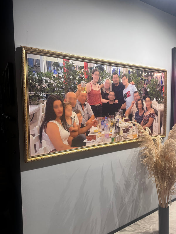 Framed photograph of a group of people at a festive gathering with Christmas trees in the background.