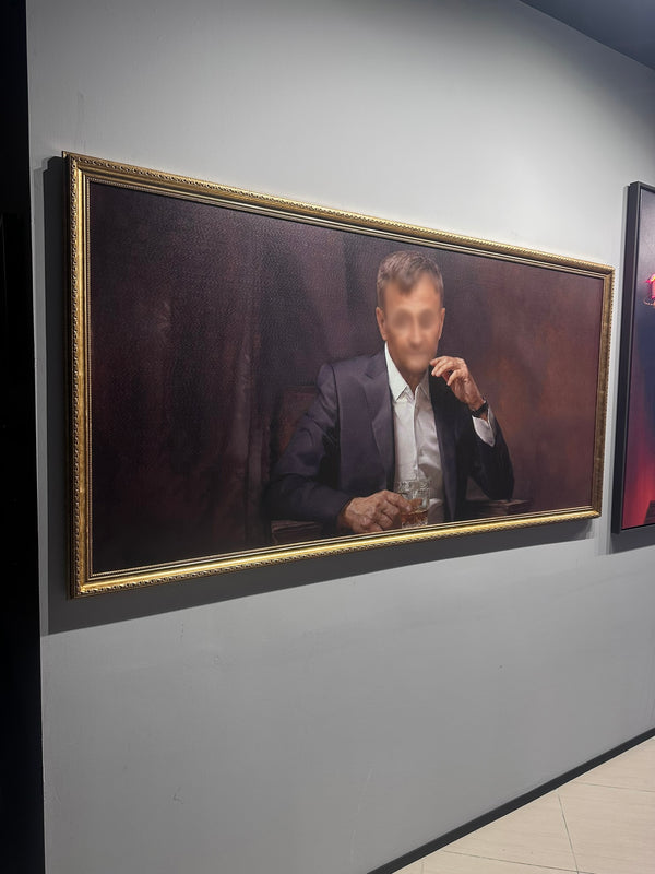 Portrait of a man in a suit with a gold frame on a gray wall.