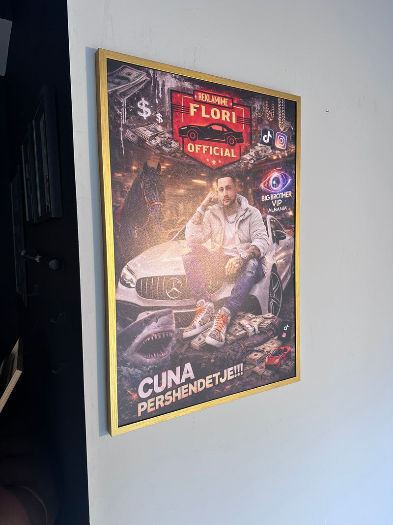 Framed poster with a person sitting on a car, featuring branding and text, on a white wall.