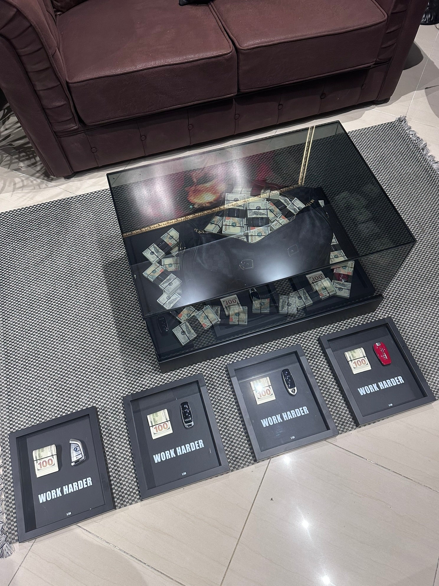 Multiple framed items on a floor with a couch in the background